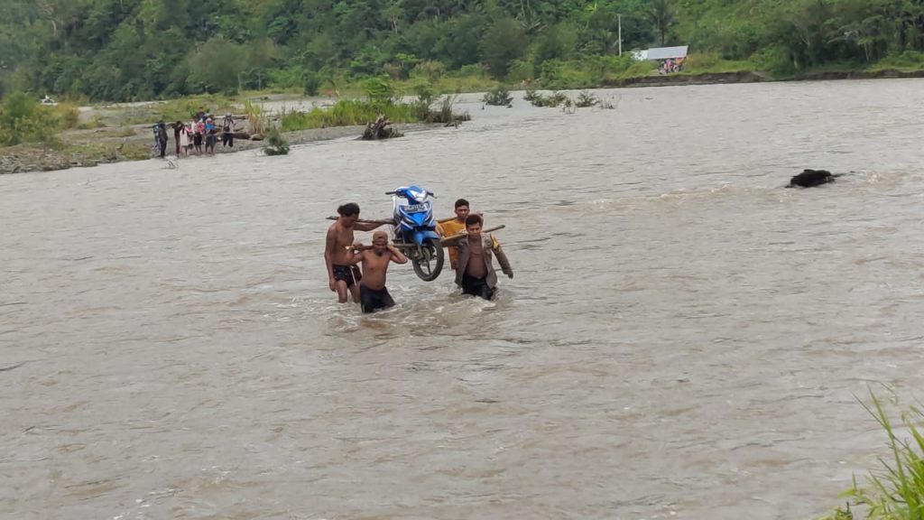 Bhabinkamtibmas Bantu Warga Seberangi Sungai-567370fd